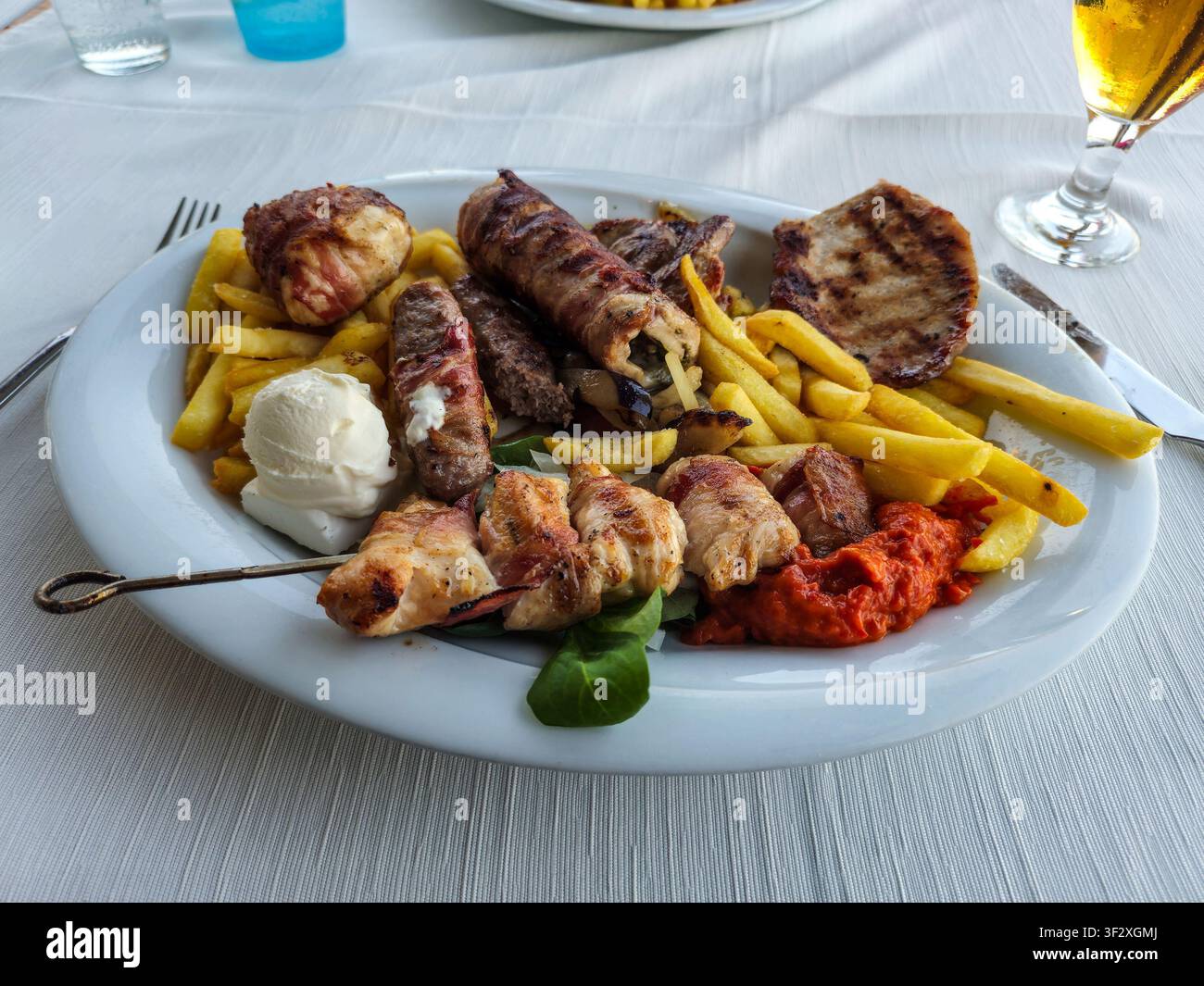 Ein Gericht mit gemischtem Grillgut und Pommes frites oder Chips Stockfoto