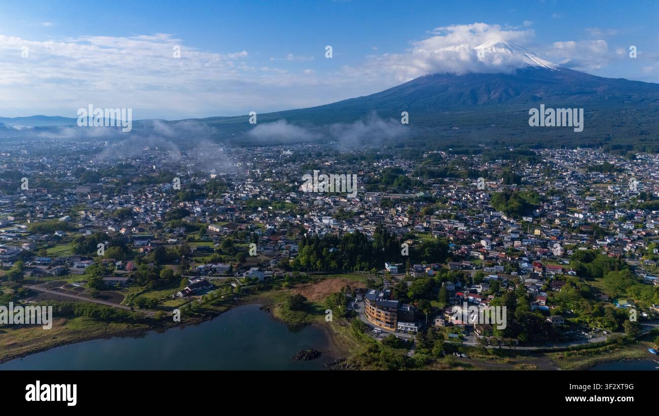 Diese Luftaufnahme zeigt den majestätischen Berg Fuji, der über der Stadt Fujikawaguchiko in der Präfektur Yamanashi, Japan, aufragt. Die umliegende Landschaft zeigt Stockfoto