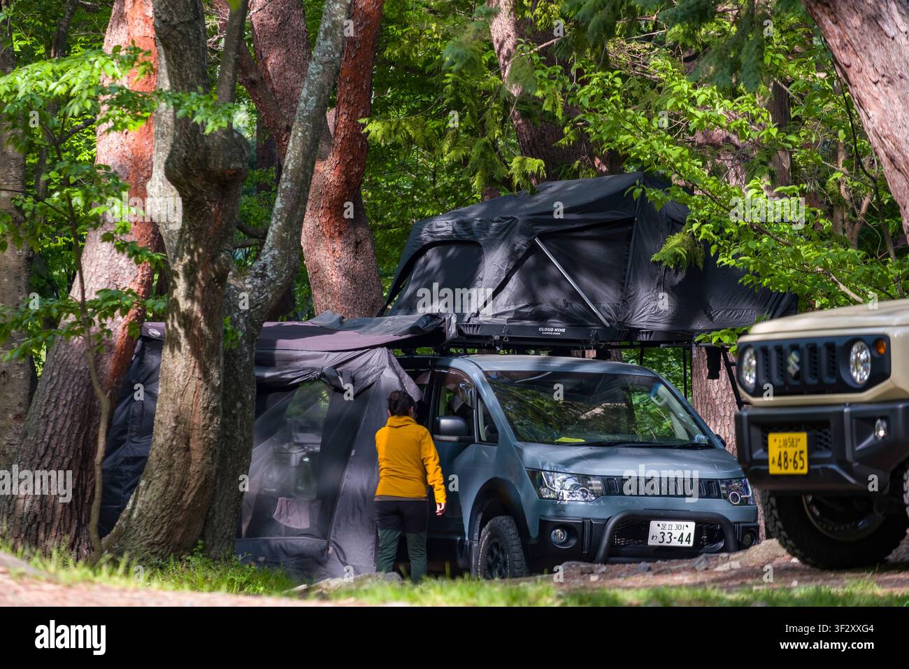 Der Koan-Campingplatz in der Präfektur Yamanashi bietet eine ruhige Auszeit, umgeben von üppigen Wäldern. Besucher können Camping mit dem Fahrzeug genießen, indem sie Roo Stockfoto