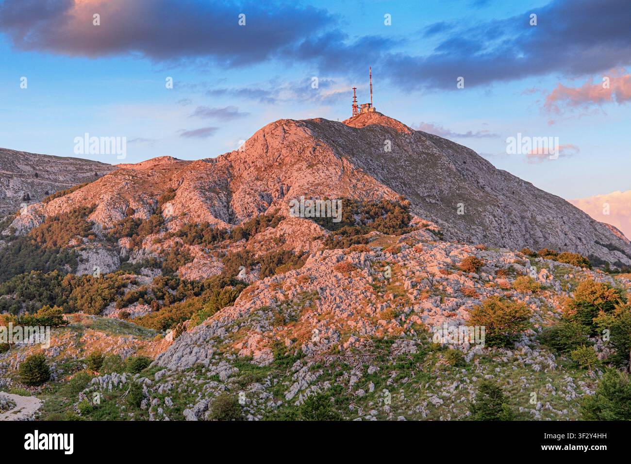 Berglandschaft des Rocky Lovcen mit Kommunikationsantennen auf dem Gipfel, beleuchtet von der warmen Abendsonne in Montenegro Stockfoto