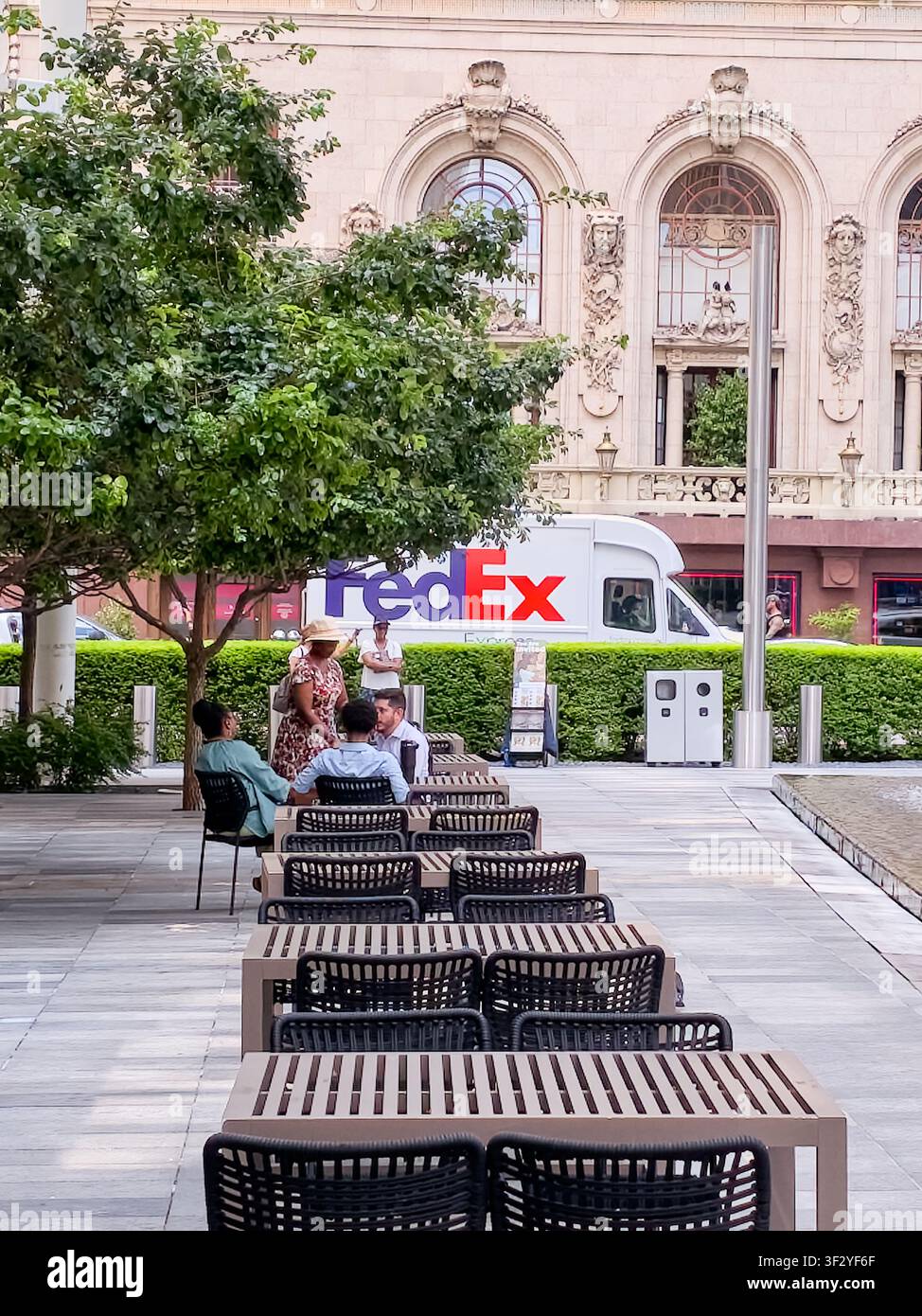 DALLAS, TX, USA - 11. JULI 2026: Ein FedEx-Lieferwagen steht neben einem historischen Gebäude mit aufwendiger Architektur in Dallas. Das Gebiet bietet Stockfoto