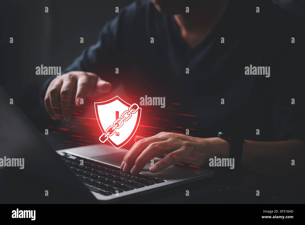 Mann tippt auf einem Laptop mit rotem Schild-Warnsymbol, das in Ketten gewickelt ist. Konzept eines Ransomware-Angriffs, eines Cybersicherheitsverstoßes, eines Systemausfalls und von Mal Stockfoto