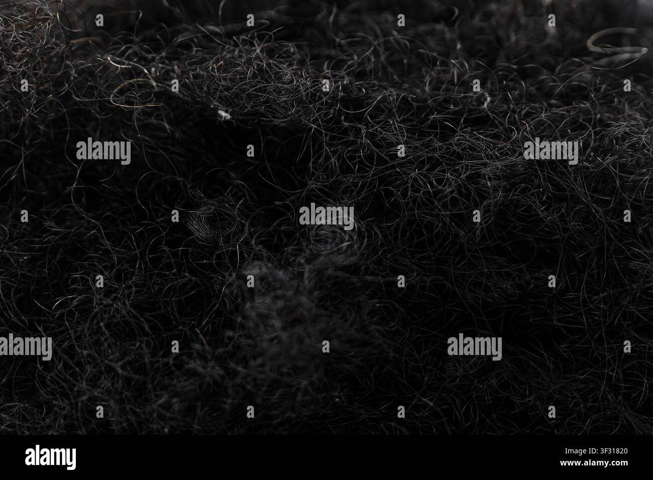Nahaufnahme der Textur von dichtem schwarzem lockigem Haar Stockfoto