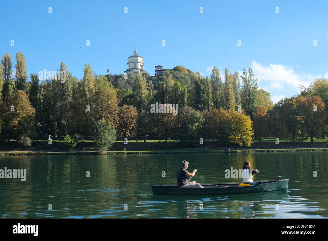 Kanutour auf dem Po in Turin, Italien, mit dem Monte dei Cappuccini und dem Faro della Vittoria-Denkmal auf dem Hügel darüber Stockfoto