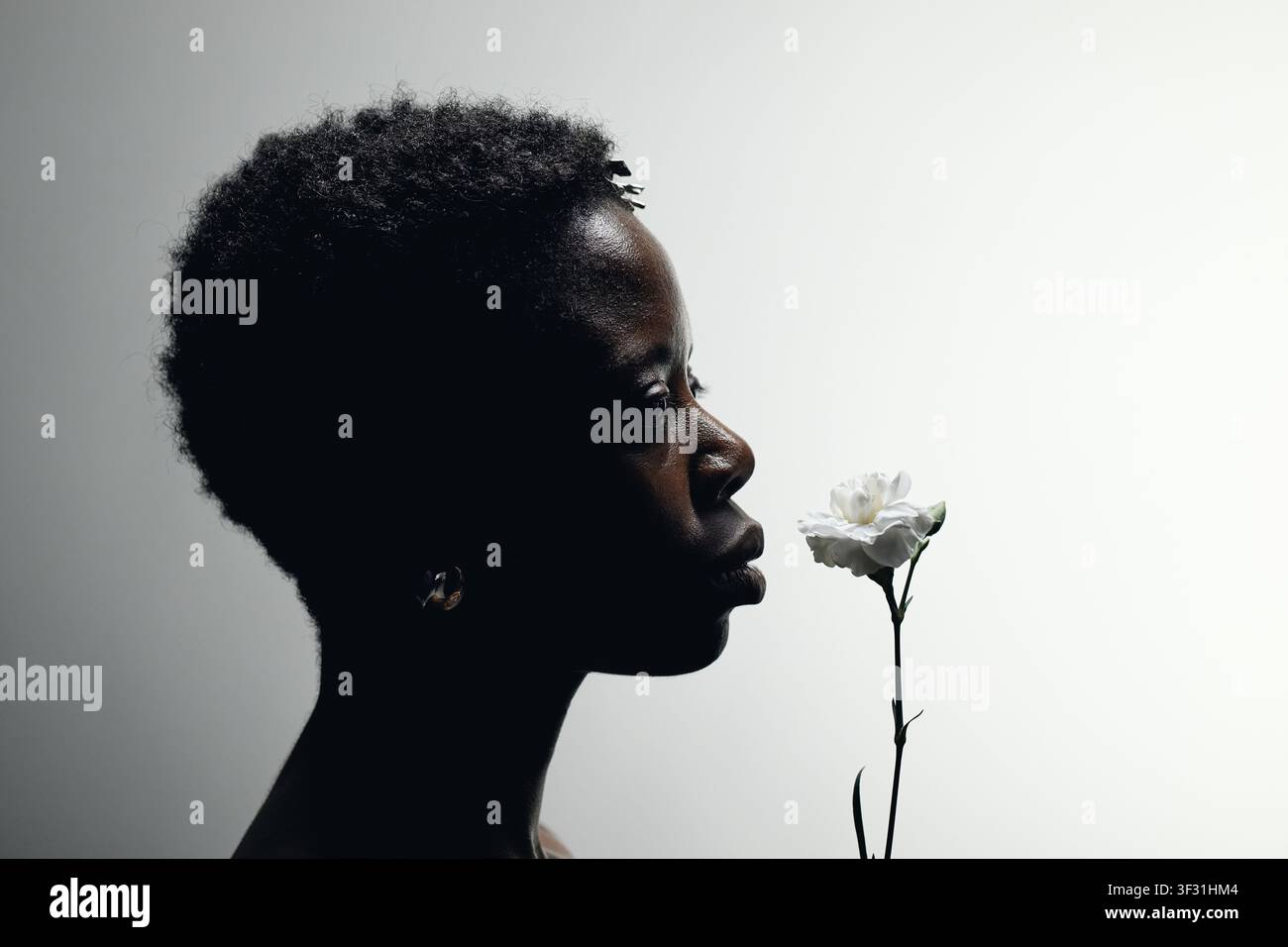 Schwarze Frau riecht Blume für Achtsamkeitskonzept Stockfoto