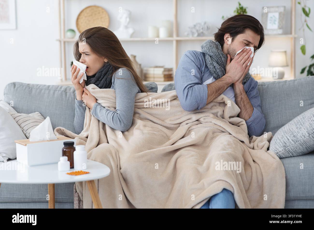 Junges Paar mit Grippe, zu Hause sitzen Stockfoto