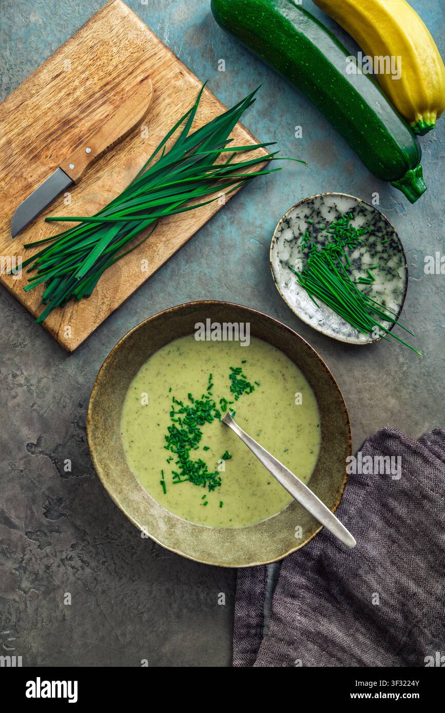 Kremige Zucchinisuppe, garniert mit frischem Schnittlauch, serviert in einer rustikalen Schüssel Stockfoto