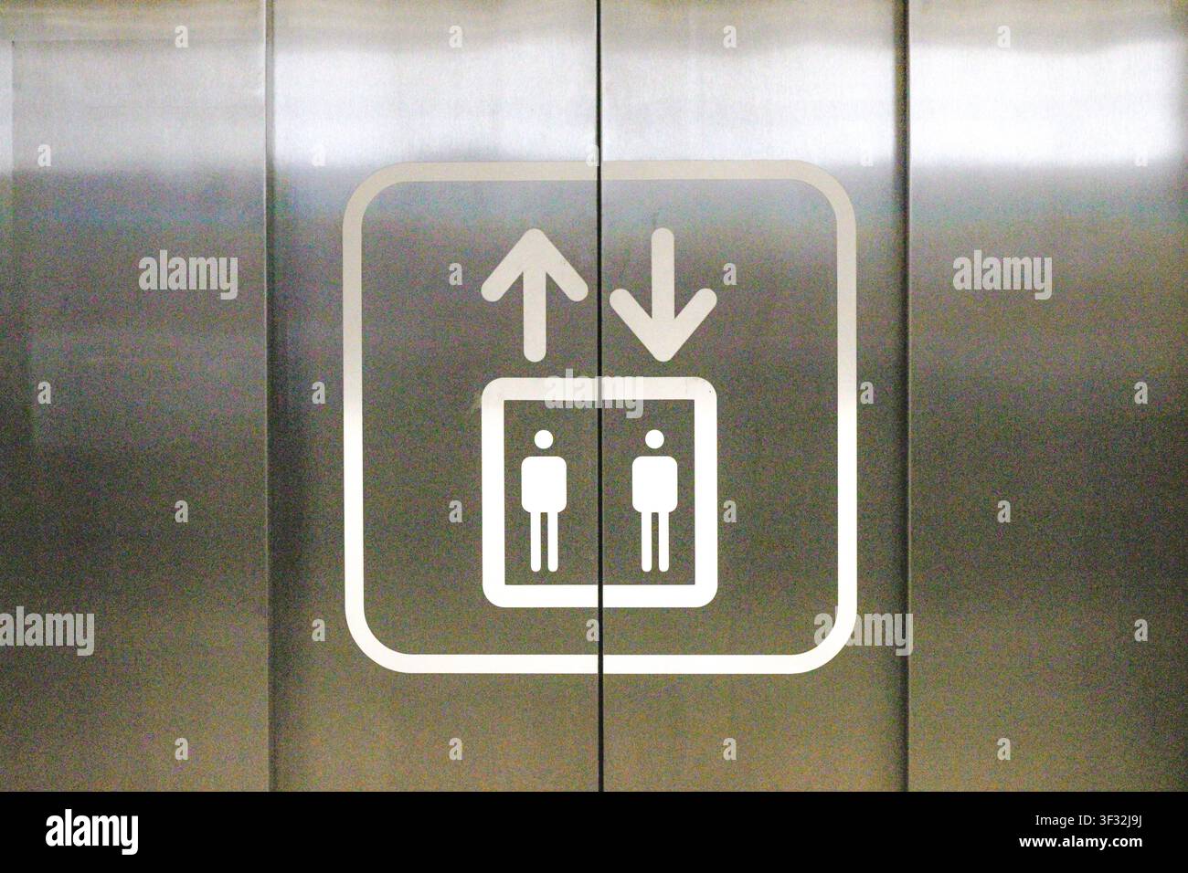Aufzugssymbol an Edelstahllift-Türen Stockfoto
