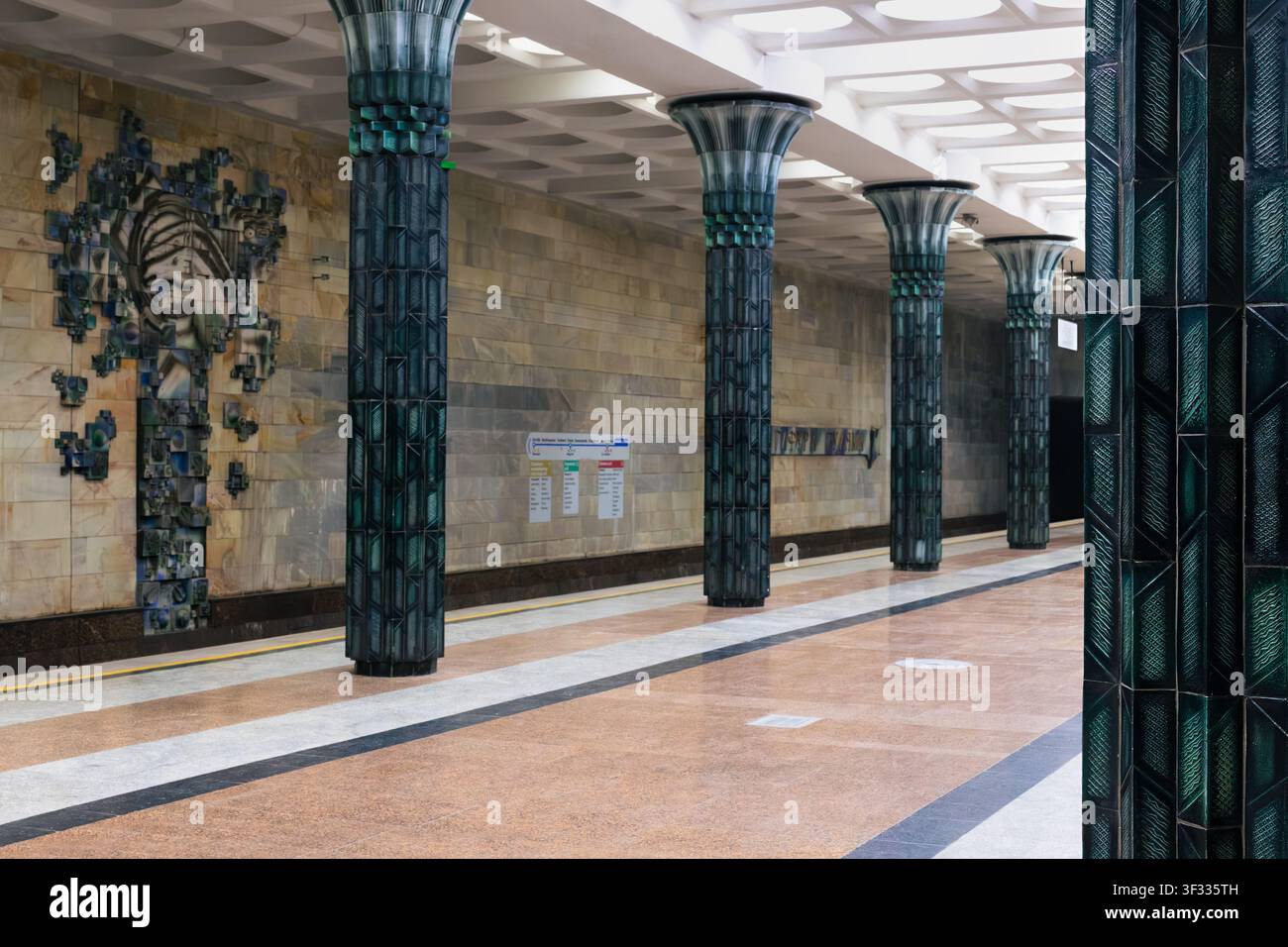 Prunkvolles Innenraum der Metrostation Gafur Gulom mit grünen Keramikstützen und skulpturalem Wandrelief in Taschkent, Usbekistan. Leere Plattform zeigt Sovi Stockfoto