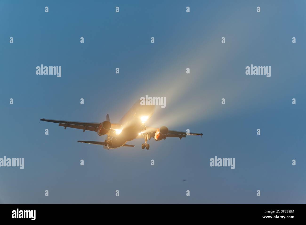 Flugzeug im Flug mit eingeschalteten Lichtern Stockfoto
