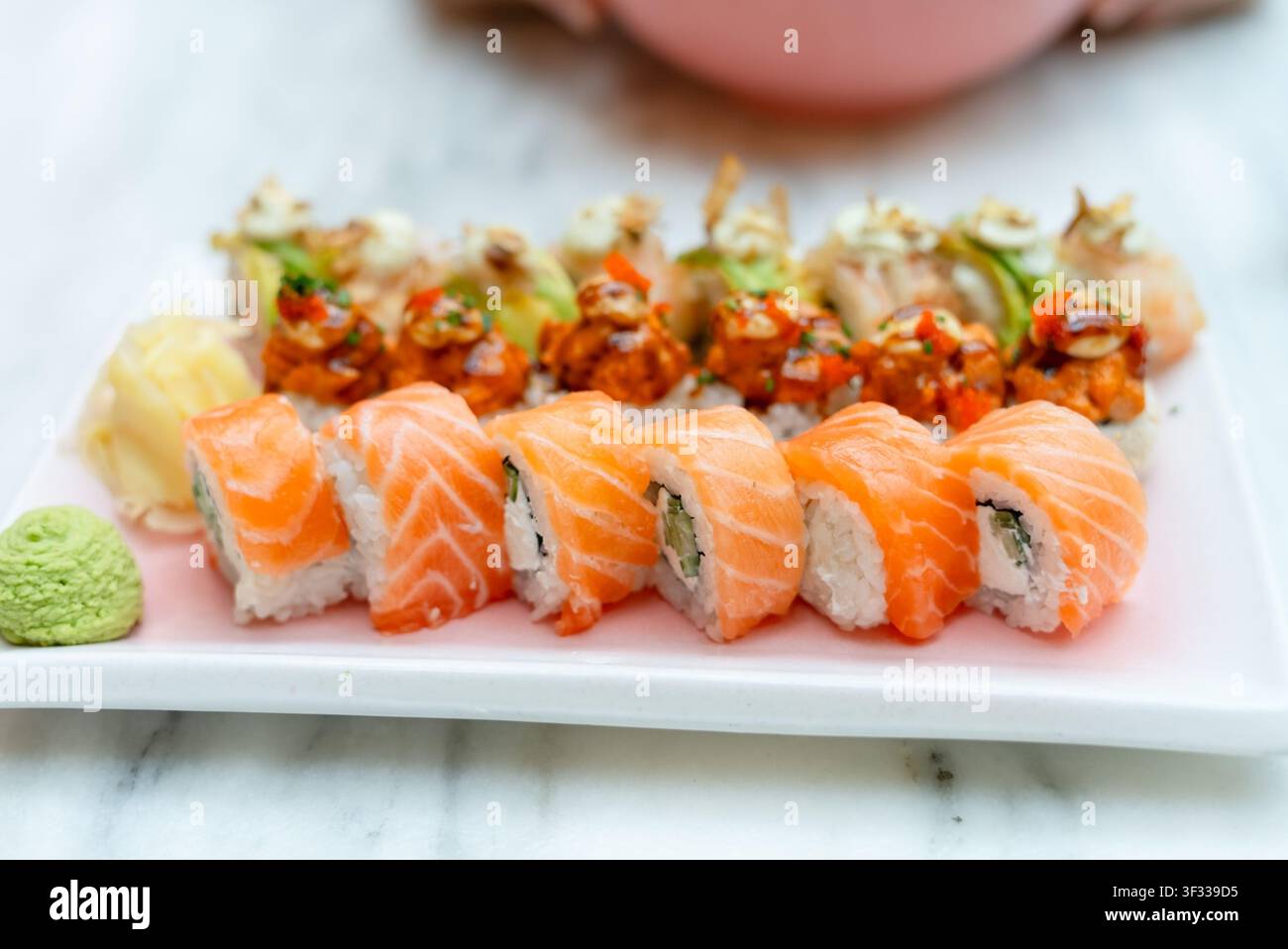 Frische Lachs-Sushi-Rollen auf einem weißen Teller mit hochwertiger japanischer Meeresfrüchte-Küche. Acht Premium-Nigiri-Stücke in appetitlicher Präsentation. Hochwertige rohe Zutaten mit kulinarischem Können Stockfoto