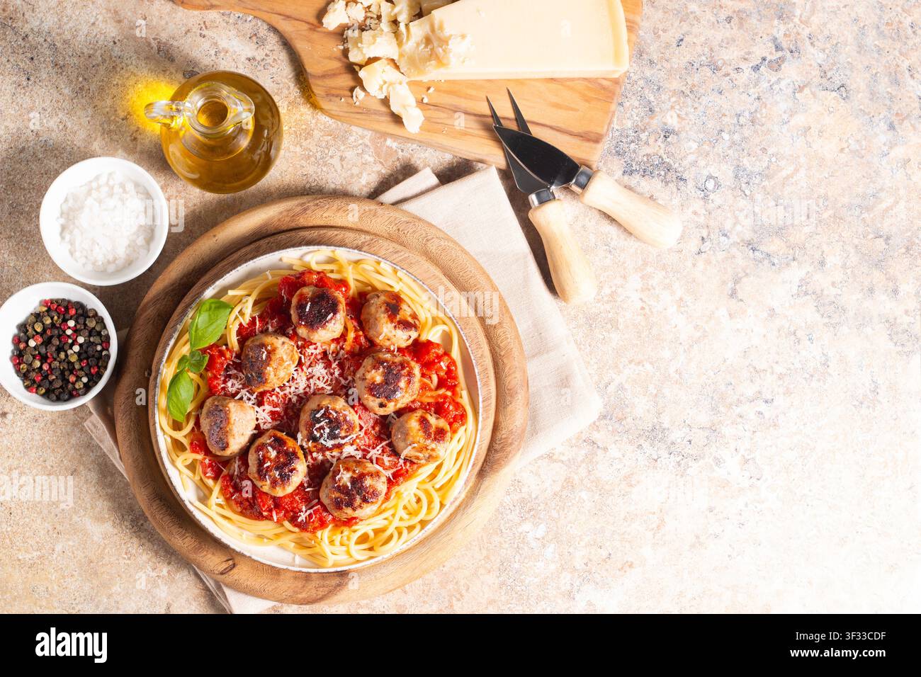 Ein Teller mit klassischen Spaghetti, garniert mit gebräunten Fleischbällchen und reichhaltiger Tomatensauce auf einem leichten Keramikgericht. Stockfoto
