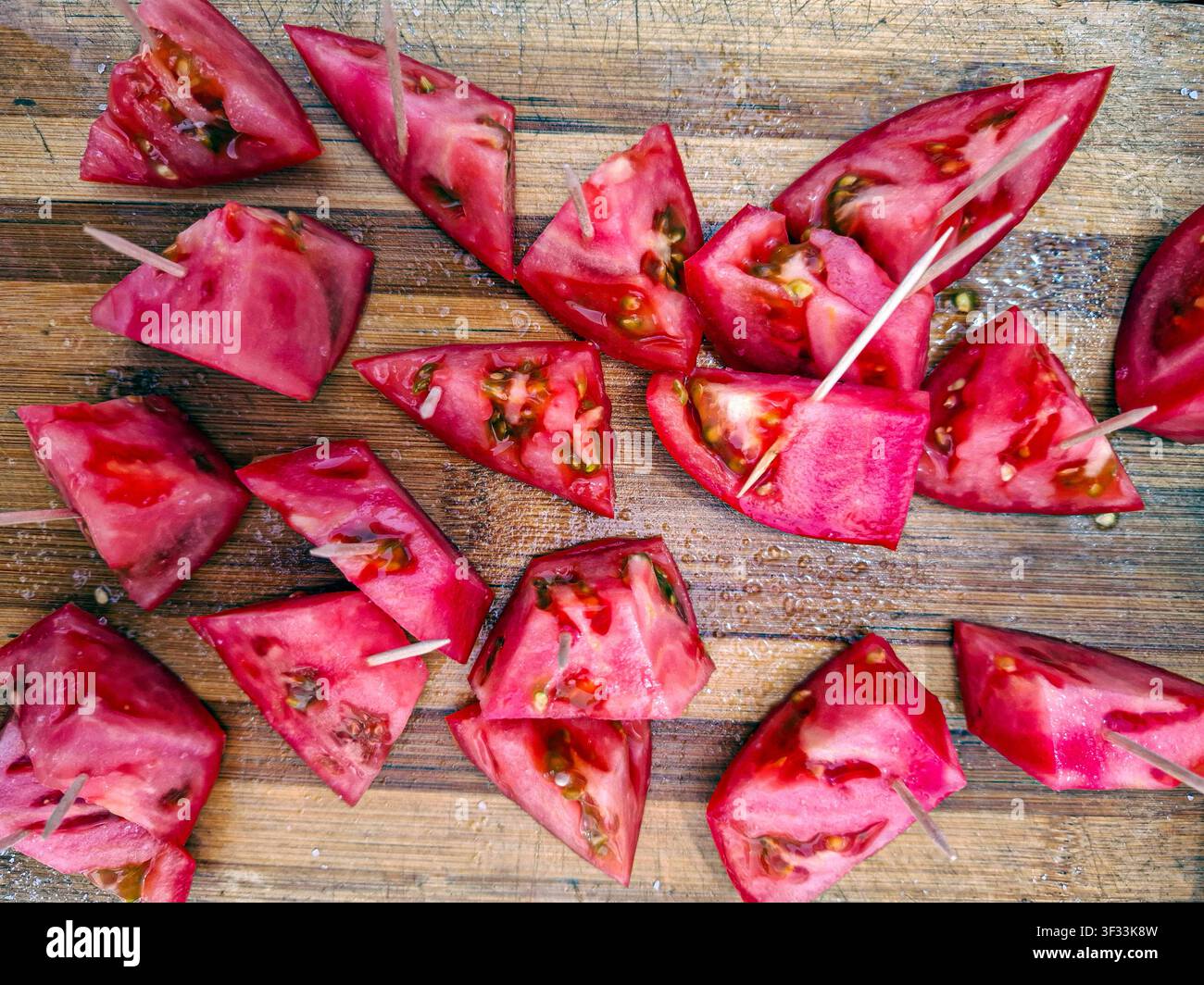 Frische Scheiben reifer Tomaten werden attraktiv zum Probieren auf einem lebhaften Bauernmarkt in Spanien präsentiert und laden Besucher ein, lokale Produkte zu verkosten. Stockfoto