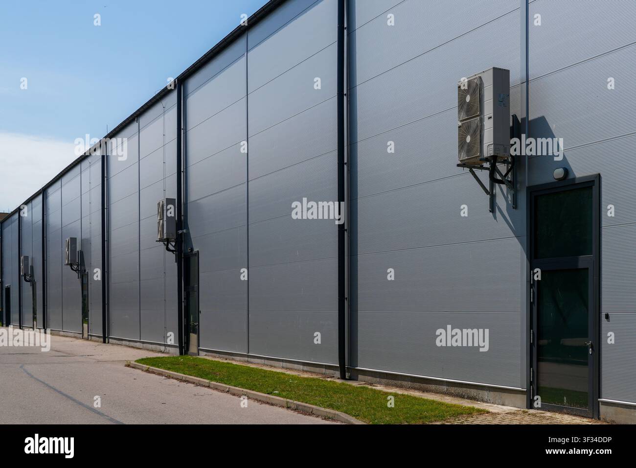 Moderne Lagerhalle mit isolierten Sandwichplattenwänden und Außengeräten für die Klimakontrolle Stockfoto