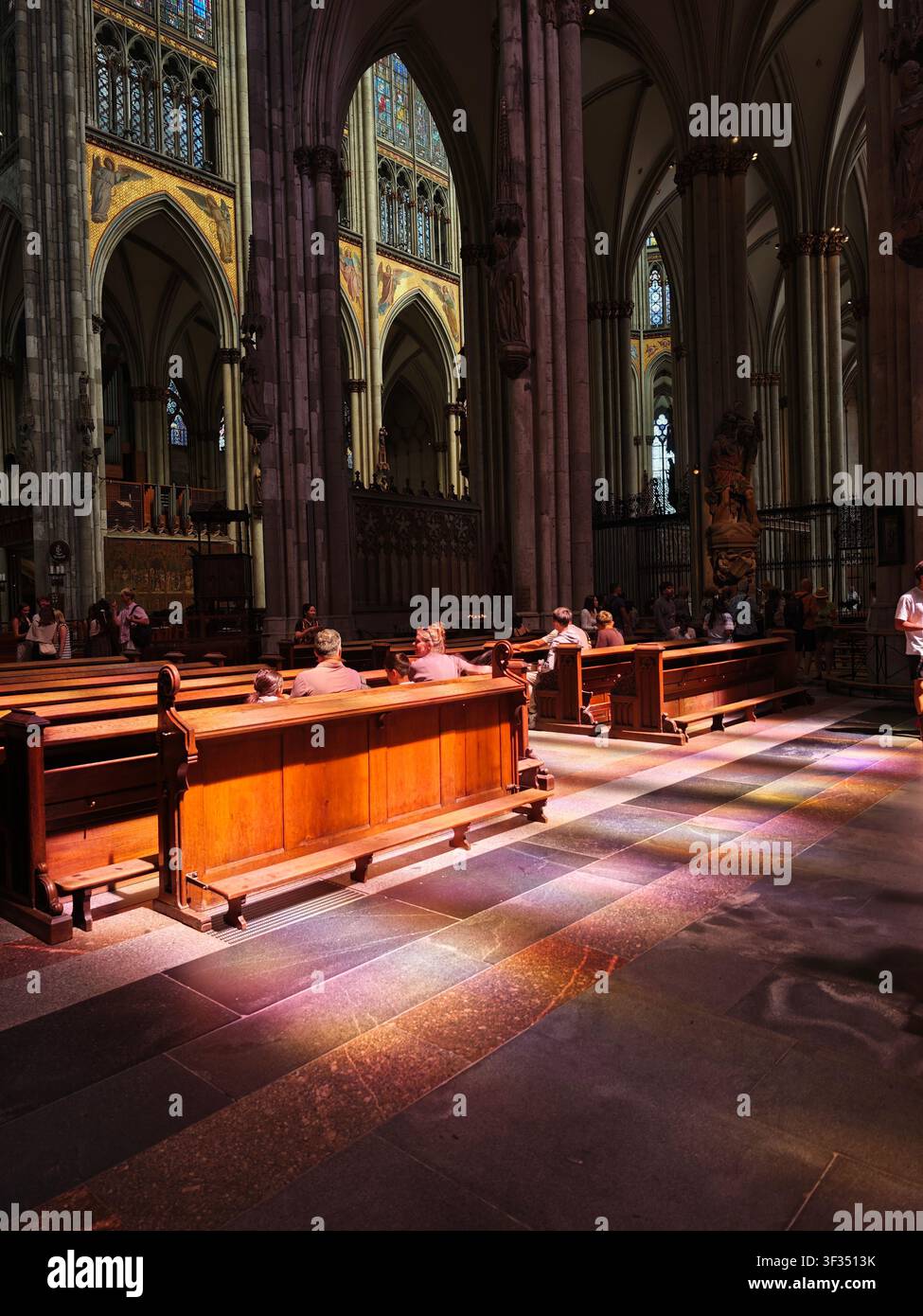 Sonnenlicht, das durch Buntglasfenster in der Kölner Kathedrale in Köln, Nordrhein-Westfalen, Deutschland, strömt. Stockfoto