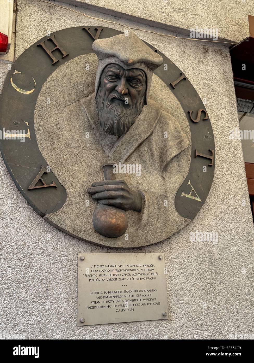 Alchymista-Relief, das einen mittelalterlichen Alchemisten vor einer Stätte in der Altstadt von Bratislava, Slowakei, darstellt. Stockfoto