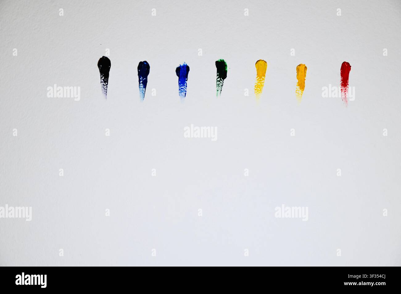 Farbenfroher Flat-Lay-Minimalismus von oben: lebendige Pinselstriche sind horizontal auf strukturiertem weißem Aquarellpapier angeordnet. Minimalistisches Design-Hintergrund mit großem Kopierraum für Kunst-, Kreativitäts-, Farbpalette-, Design- und Bildungskonzepte. Reihe auf weißem Papier mit Kopierraum. Hochwertiges Foto Stockfoto