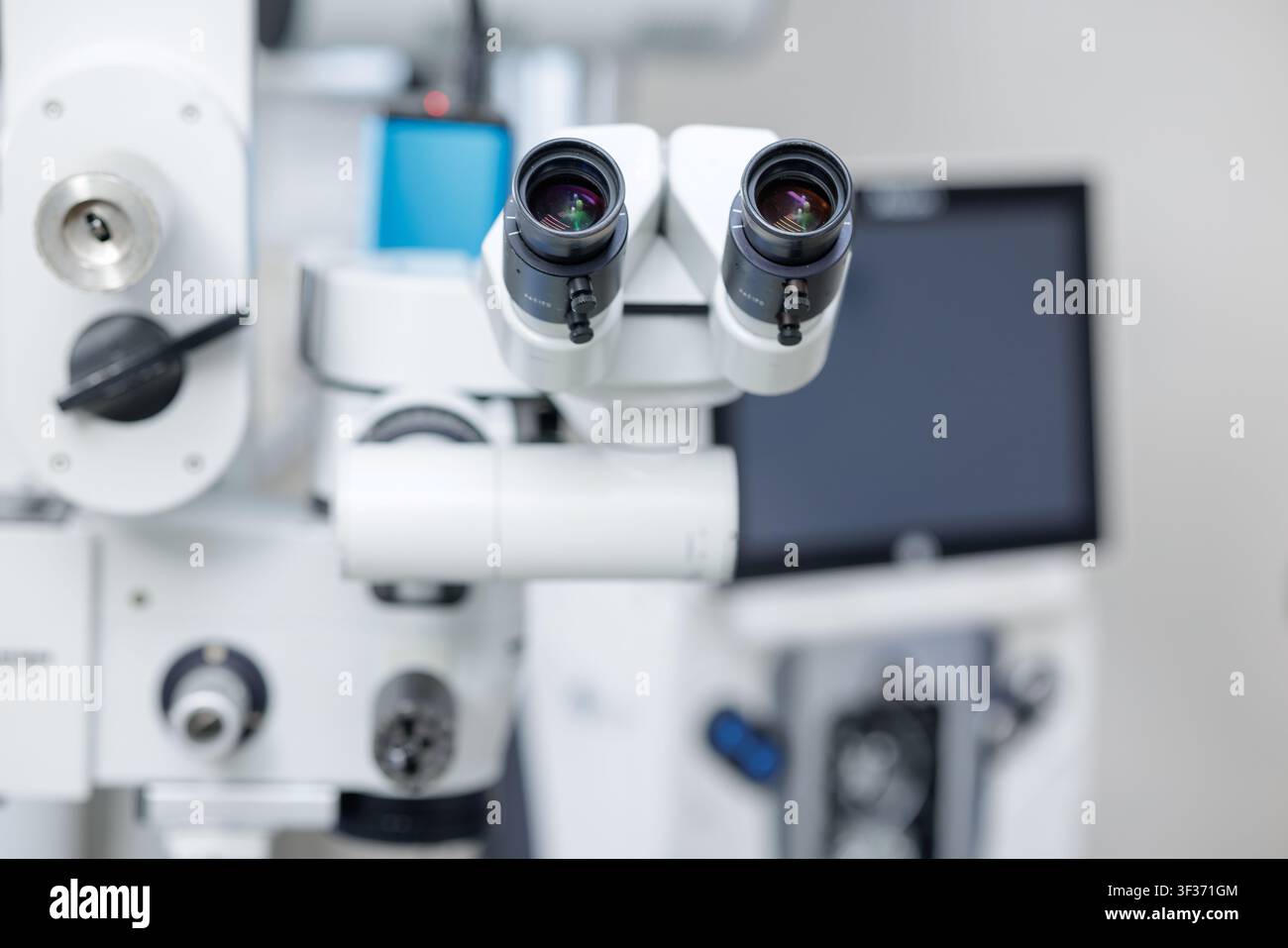 Eine Nahaufnahme eines High-Tech-Operationsmikroskops, das für Präzision in chirurgischen Umgebungen entwickelt wurde, zeigt seine beiden Okulare und die komplexe Steuerung Stockfoto