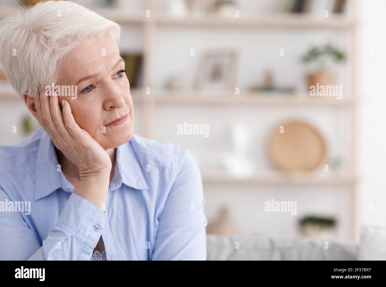 Porträt Einer Traurigen, Nachdenklichen Senior-Frau, Die Zu Hause Sitzt Und Wegschaut Stockfoto