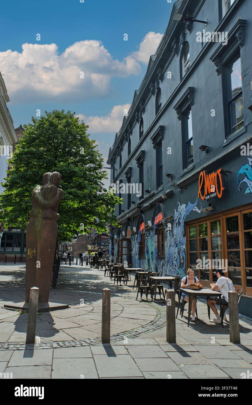 An einem sonnigen Tag in Liverpools Bold Street versammeln sich Freunde an Außentischen und genießen gutes Essen und lebhafte Gespräche im Schatten eines Baumes. Stockfoto