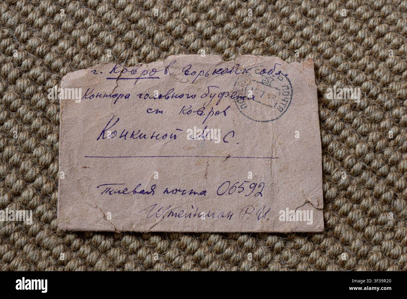 Archivfrontbrief aus der UdSSR, Vorderansicht mit alten Tinteninschriften, einem Poststempel, offiziellen Nummern, Namen und abgenutzten, verfallenen Rändern. Stockfoto