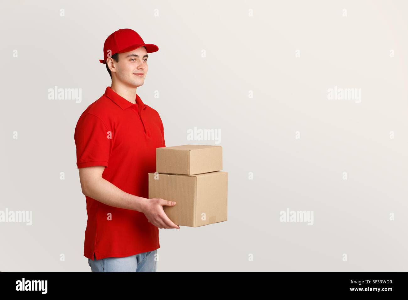 Online-Bestellung und Kurier. Liefermann in roter Uniform hält Kisten in Händen Stockfoto