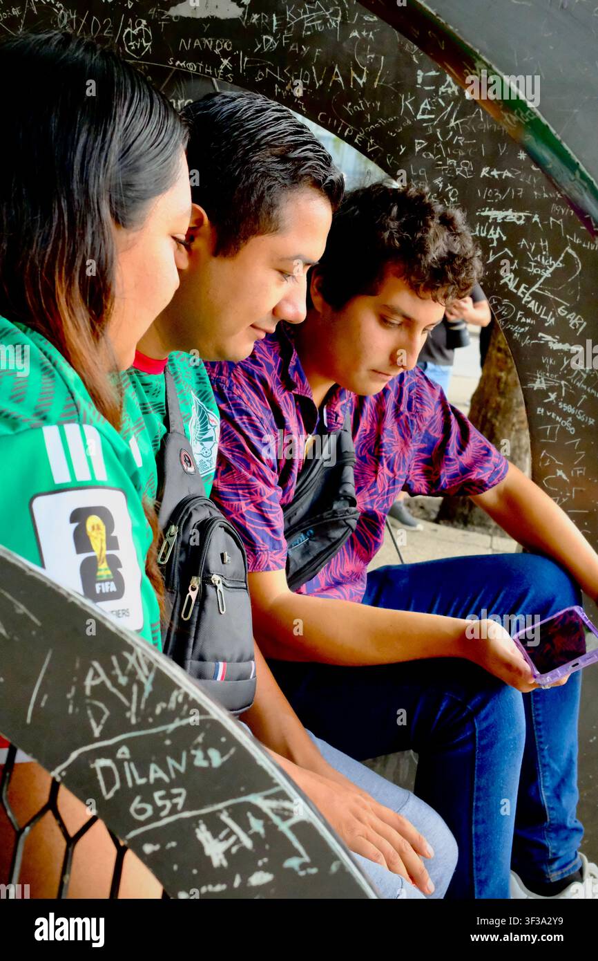 Mexiko-Stadt, CDMX, Mexiko – 19. Juli 2026: Junge Fans beobachten ein Weltmeisterschaftsspiel auf dem Smartphone an der Bushaltestelle Stockfoto