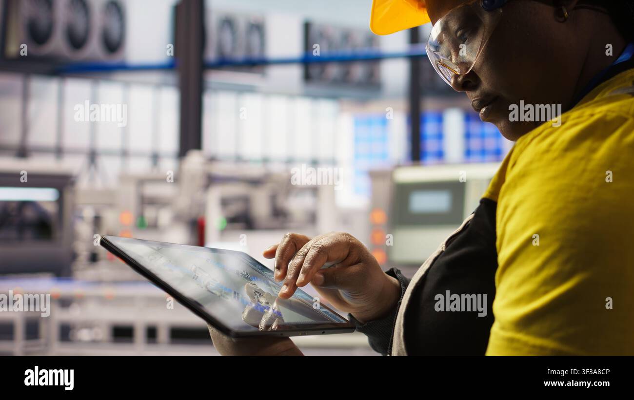 Industrie-4.0-Fabrikingenieur entwirft neue Robotermaschinen mit CAD-Anwendung auf dem Tablet. Intelligenter Fabrikarbeiter optimiert die Ausrüstungslayouts auf dem Fabrikboden, Kamera eine Nahaufnahme Stockfoto