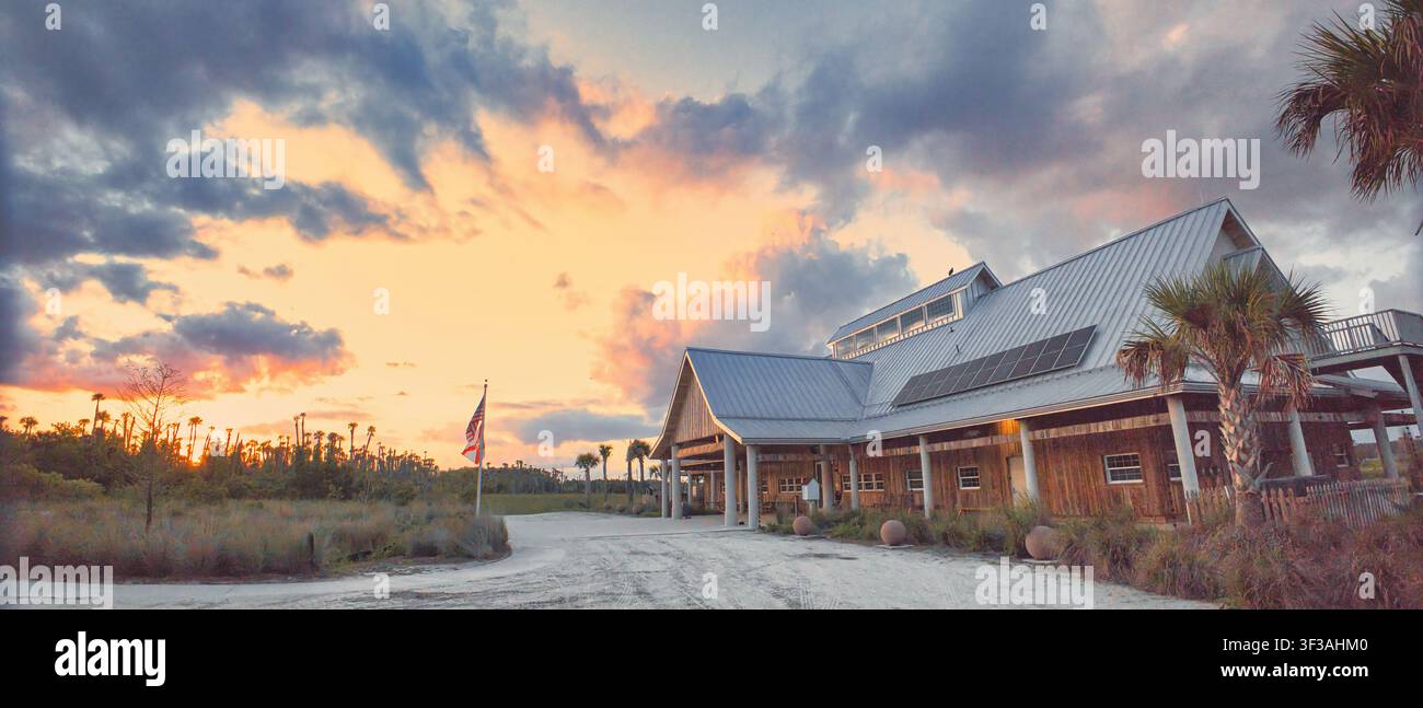 Dramatischer Sonnenuntergang über dem Orlando Wetlands Park in der Nähe des Besucherzentrums, mit leuchtendem Himmel und Spiegelungen über den ruhigen Feuchtgebieten Floridas. Stockfoto