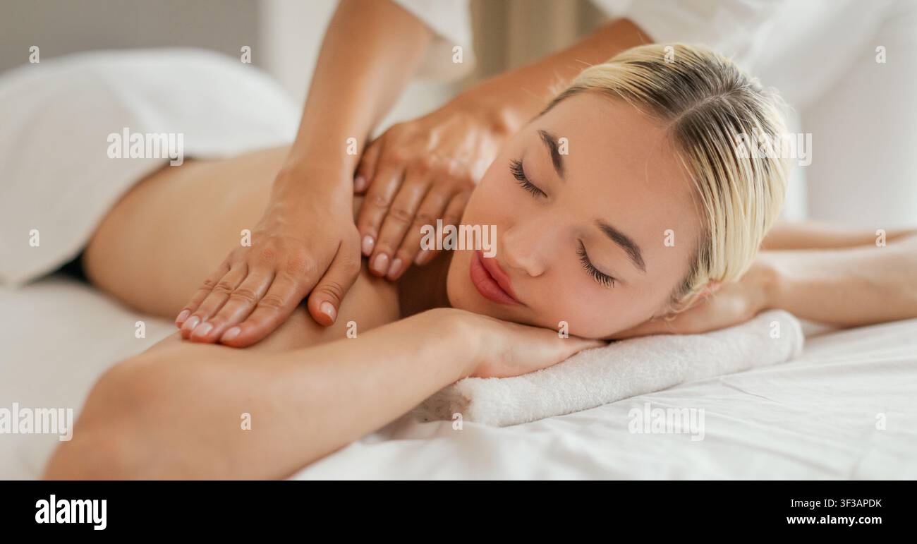 Frau erhält Schultermassage im Cozy Spa Stockfoto