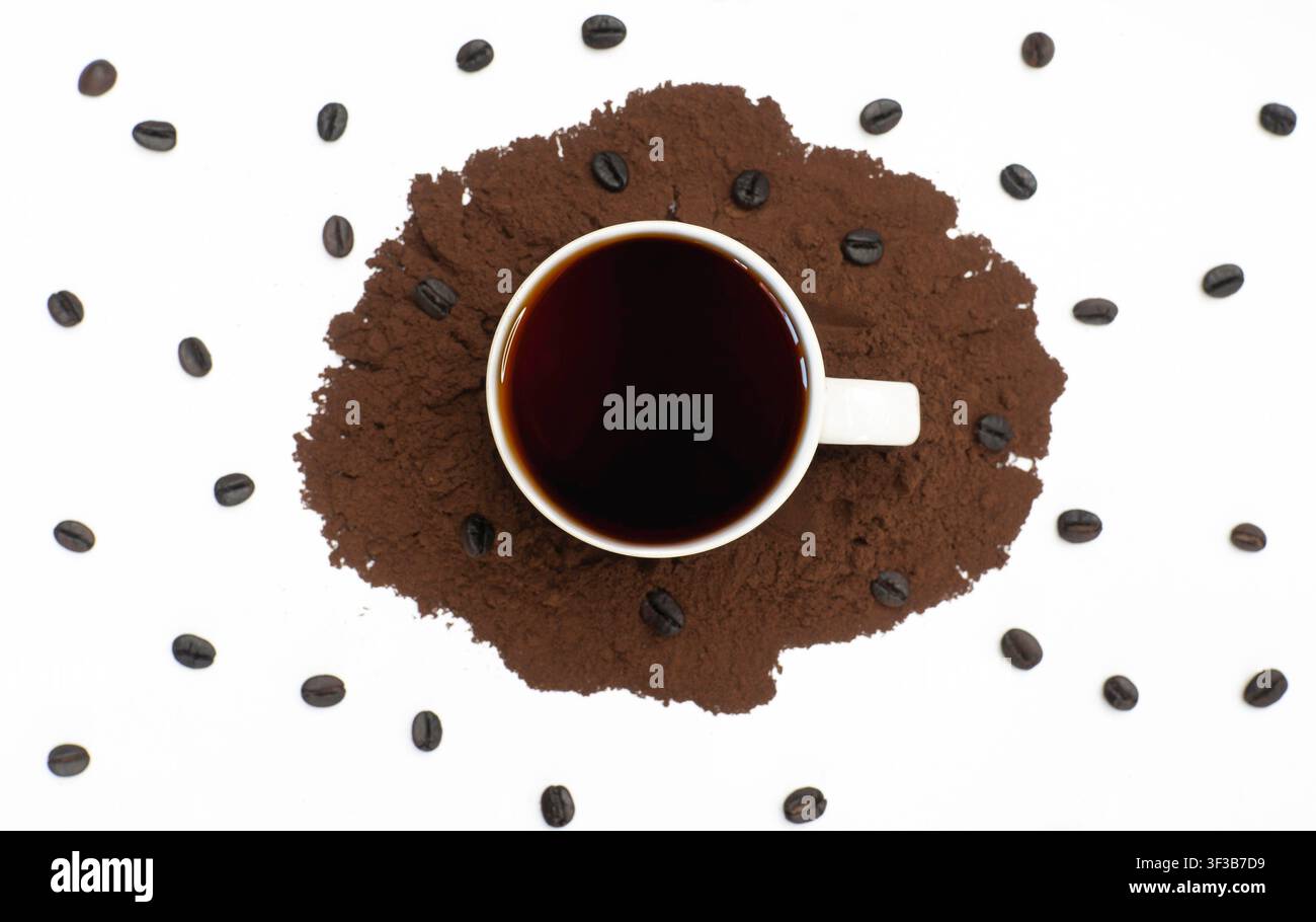 Schwarze Kaffeetasse auf gemahlenem Kaffeepulver mit verstreuten Bohnen Stockfoto