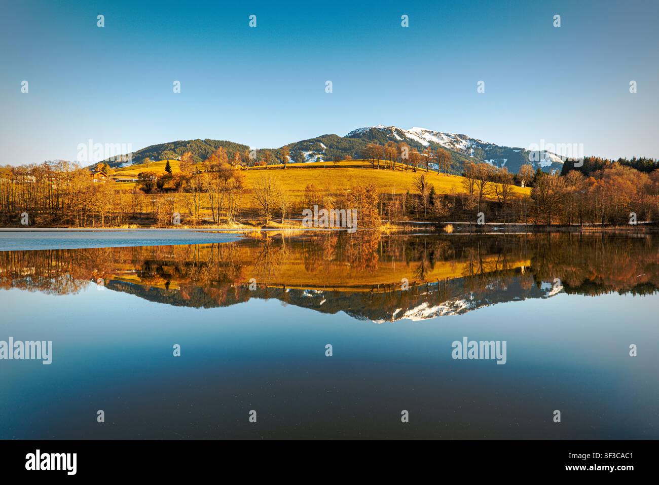 Panoramablick auf den Berg Schwalbenwand, der sich im ruhigen Wasser des Ritzensees bei Saalfelden, Salzburg, Österreich spiegelt. Stockfoto