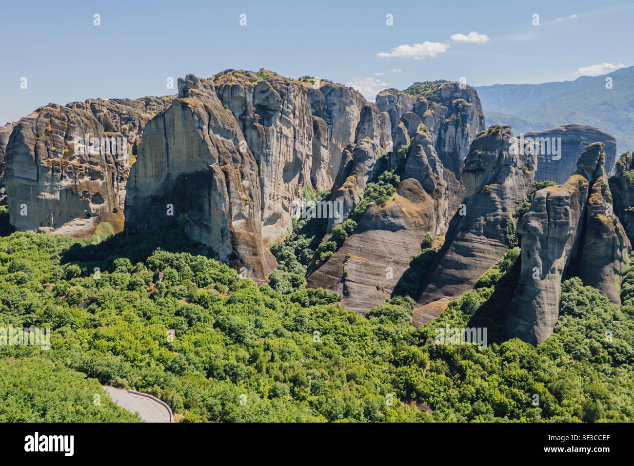 Hochwinkel-Luftaufnahme massiver Felsformationen, die über einer grünen Tal-Waldlandschaft in der berühmten Meteora-Unesco-Weltregion nahe Kalambaka G aufragen Stockfoto
