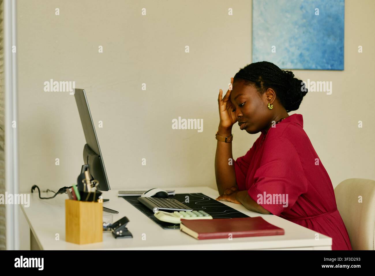 Schwarze Frau erlebt Arbeitsstress, während sie am Bürotisch sitzt Stockfoto