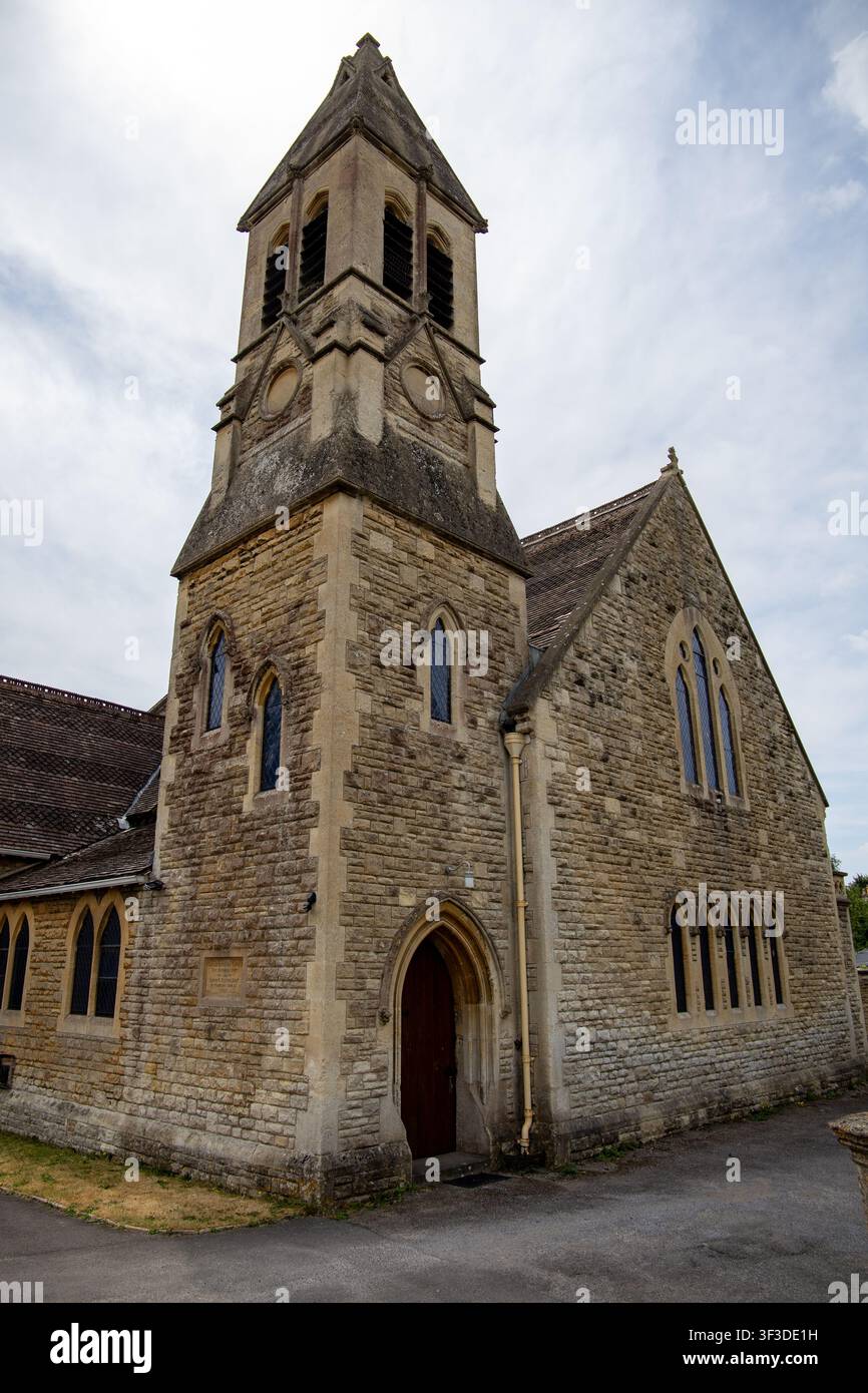 Steinkirche mit hohem Glockenturm und gewölbtem Eingang vor einem bewölkten Himmel United Reformed Church Holt Wiltshire Stockfoto