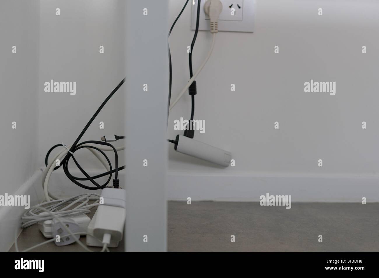 Minimaler Arbeitsplatz mit Kabeln und Stromadaptern Stockfoto