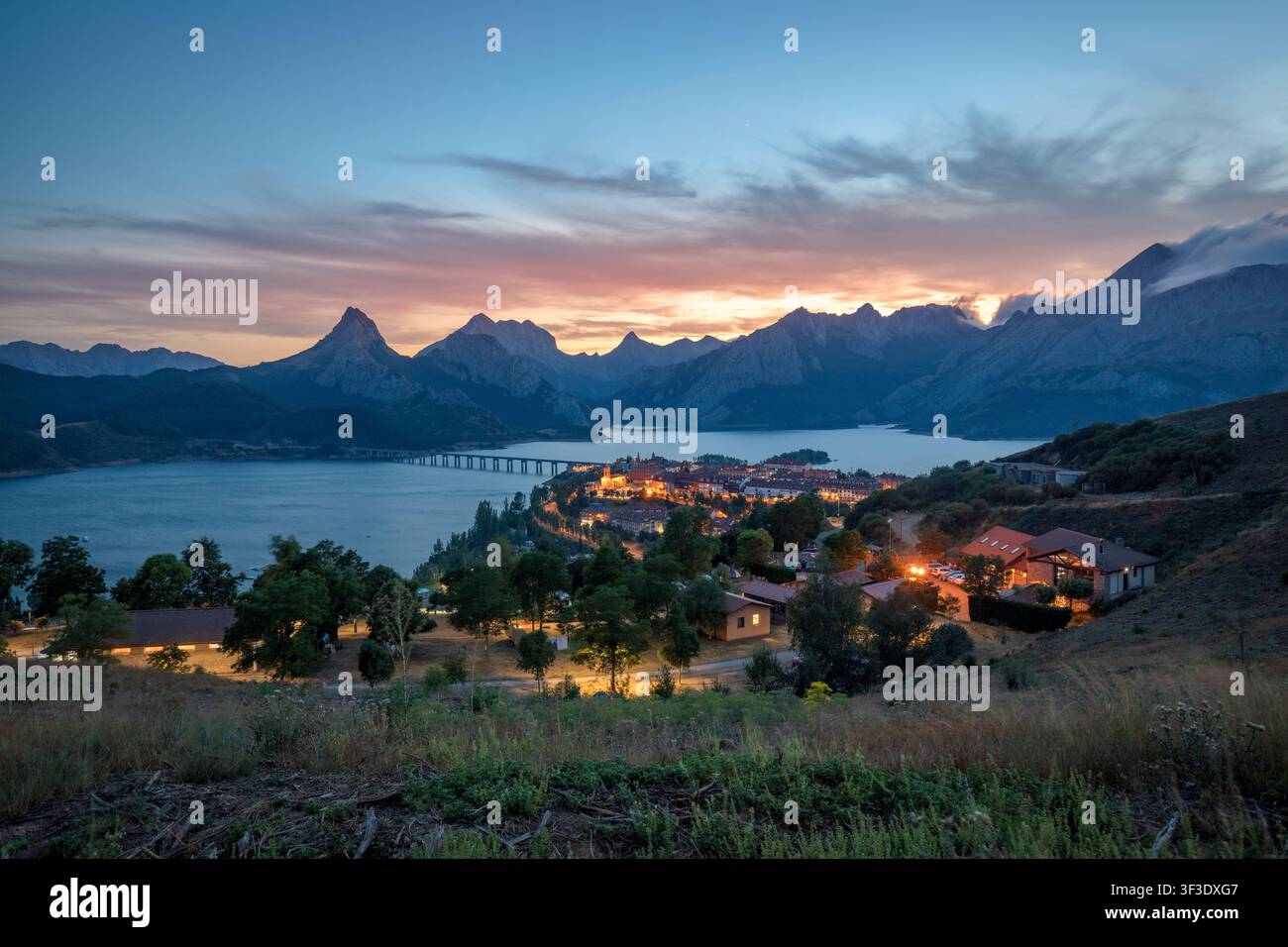 Stausee Riaño mit der beleuchteten Stadt bei Nacht, León, Kastilien und León, Spanien Stockfoto