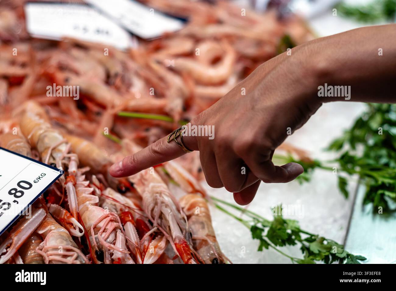 Hand wählt frische Meeresfrüchte auf einem lokalen Markt aus Stockfoto