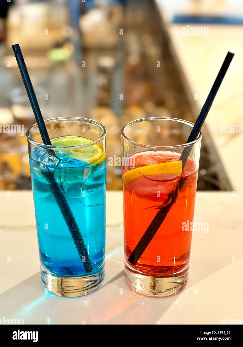 Zwei farbenfrohe Cocktails mit Strohhalmen auf einem Tisch in einer Cocktail-Lounge. Keine Menschen. Stockfoto