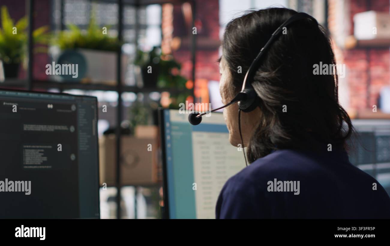 Callcenter-Agent verwendet einen KI-Chatbot, um schnelle und präzise Antworten auf häufige Kundenanfragen zu geben. Kundenservice-Mitarbeiter generiert automatisierte Antworten für Kunden mit KI, Kamera A Stockfoto
