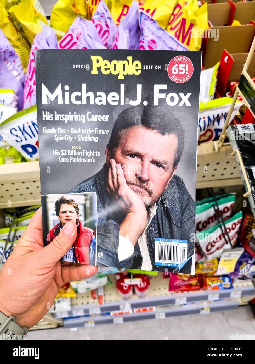 DALLAS, TX, USA - 19. JULI 2026: Ein Kunde hält eine Sonderausgabe des People Magazine mit Michael J. Fox in einem Einzelhandelsgeschäft. Das Cover hebt hi Stockfoto