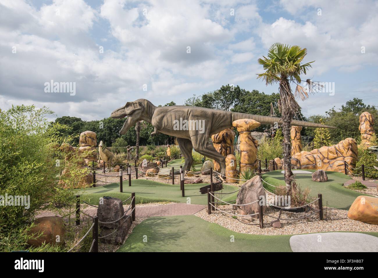 Dinosaurier-Themen-Minigolfplatz mit lebensgroßen Dinosaurierfiguren, Kunstrasen-Grüns und felsiger Landschaft........Bents Garden Centre. Stockfoto