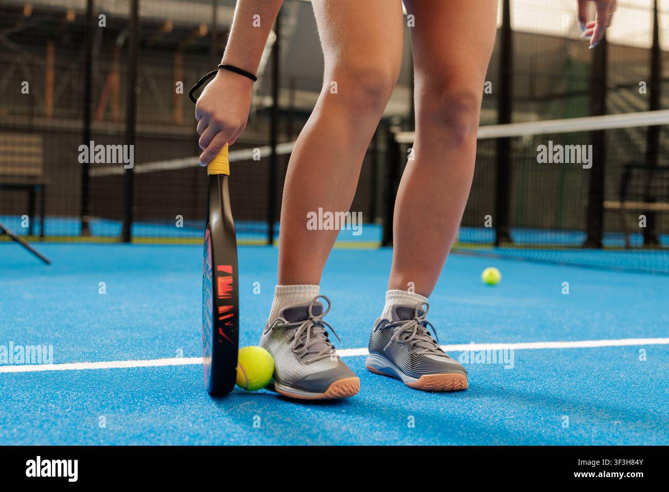 Ein Trainer demonstriert einem Spieler während einer Padel-Tennis-Trainingseinheit Techniken, wobei der Schwerpunkt auf der Entwicklung von Fähigkeiten und athletischer Leistung liegt auf einem Stockfoto