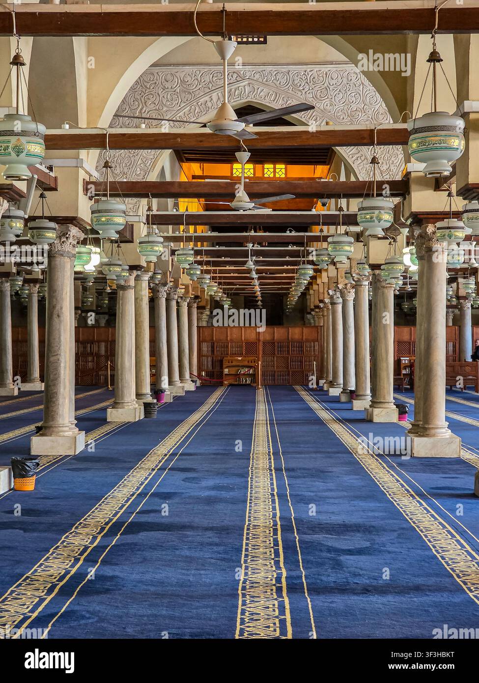 Gebetshalle mit Marmorsäulen, hängenden Laternen und blauem Teppich in der Al-Azhar-Moschee, historisches Kairo, Ägypten. - Smartphone-aufgenommenes Stockfoto