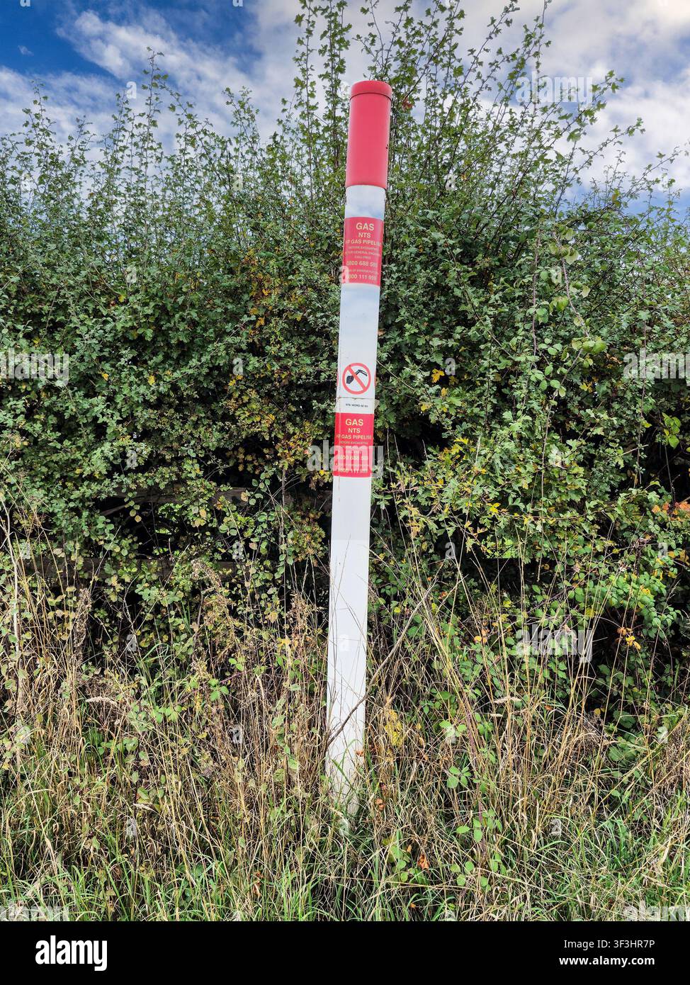 Ein roter und weißer Marker für eine NTS-Hochdruck-Gasleitung, England, UK Stockfoto