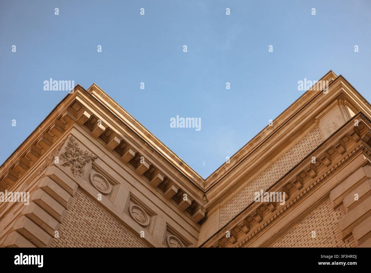 Eckgebäude mit historischer Architektur und zunehmendem Mond am blauen Himmel Stockfoto