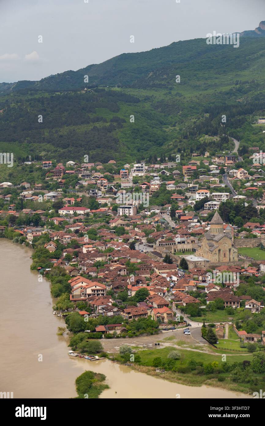 Mtskheta, Georgien, zeigt die Svetitskhoveli-Kathedrale und historische Gebäude entlang des Kura-Flusses und bietet einen panoramischen Luftblick auf die antike Stadt Stockfoto