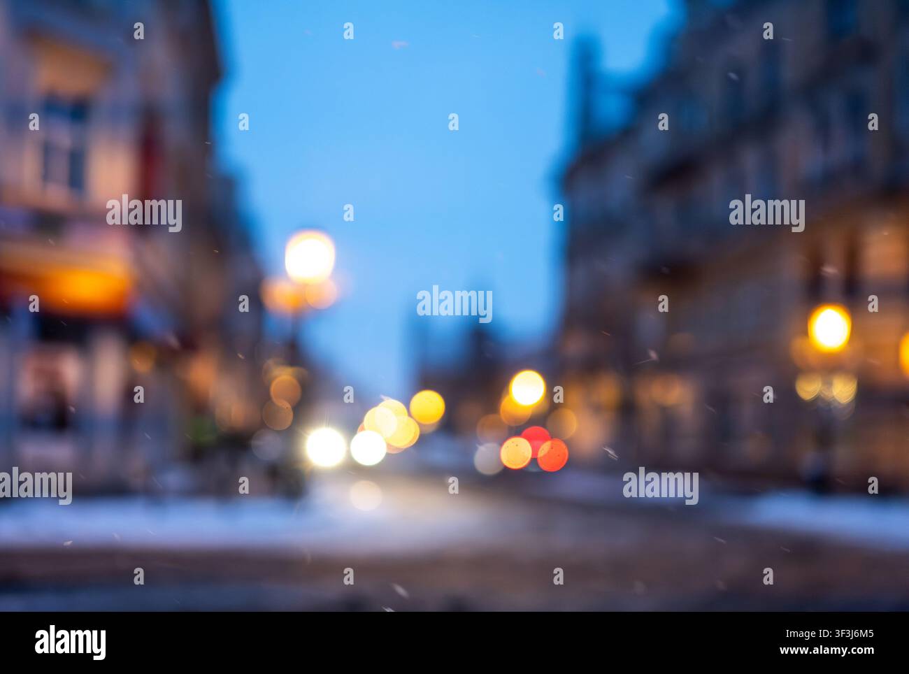 Unscharfes Foto einer Winterstraße am Abend mit Stadtlichtern Stockfoto
