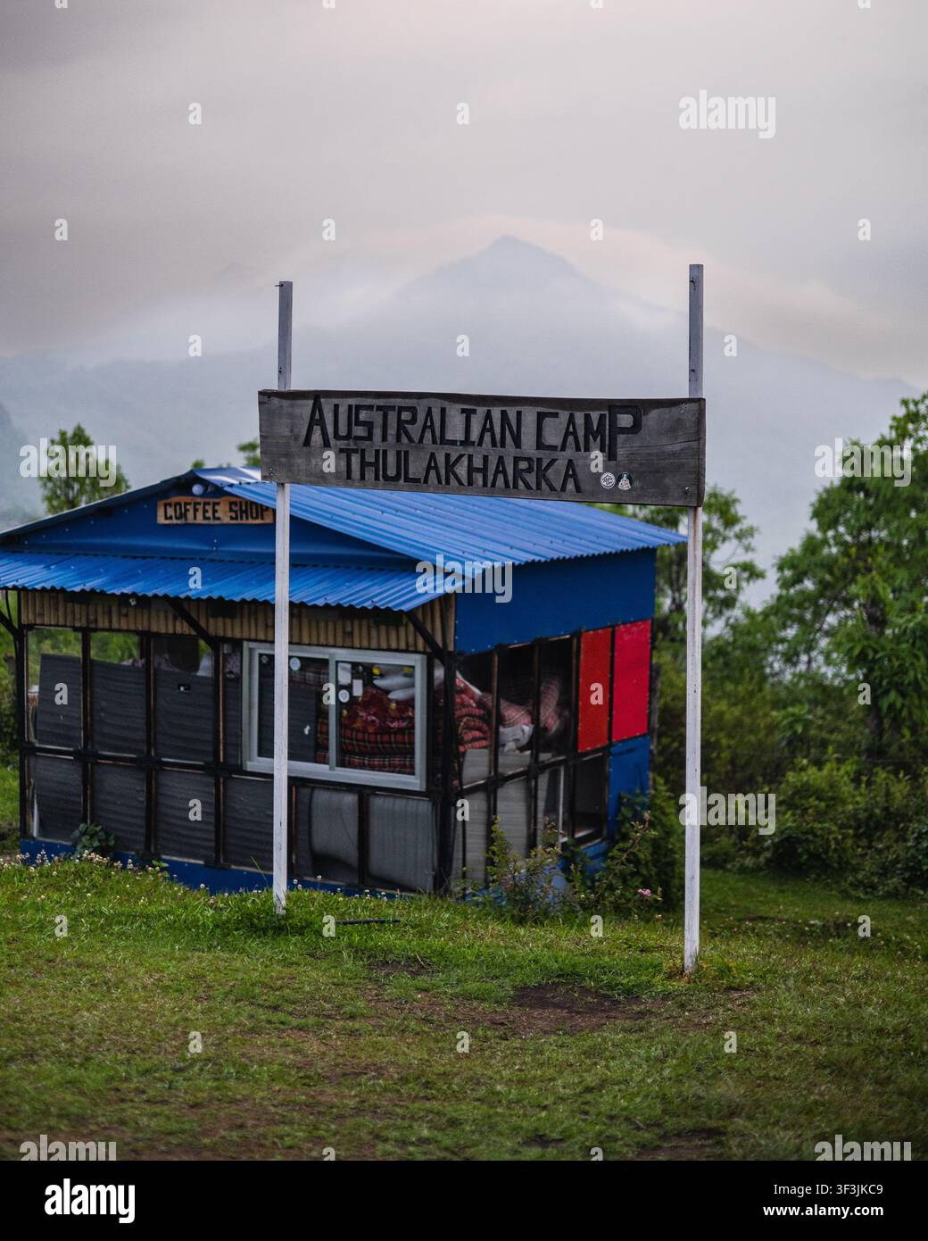 Ansicht des Schilds des australischen Lagers Thulakharka, das vor einem kleinen blauen Café mit Bergkulisse in Pokhara, Gandaki-Provinz steht Stockfoto