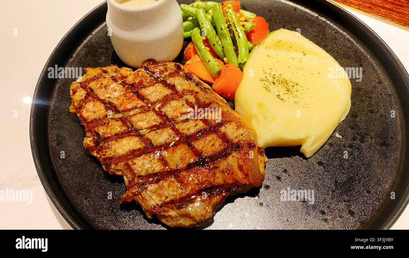 Zartes gegrilltes Metzgersteak mit charakteristischen Brandspuren und einem köstlich anmutenden Aussehen, ideal für Restaurantmenüs - Smartphone-aufgenommenes Stockfoto